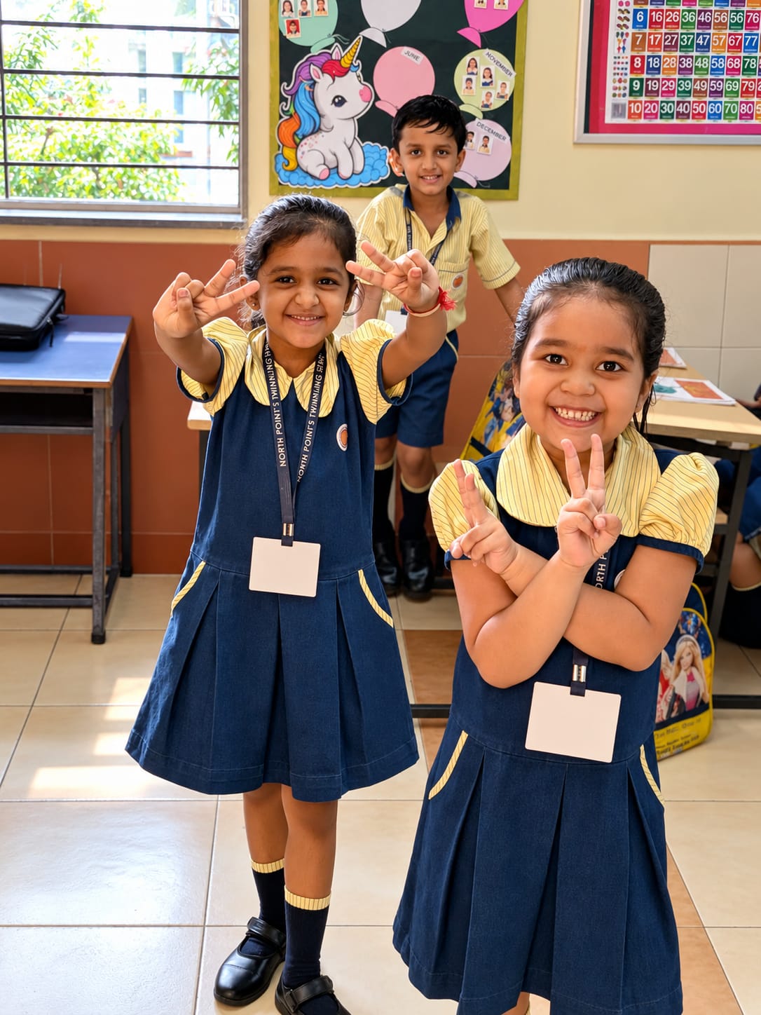 Three North Point School Early Years students smiling together in their classroom