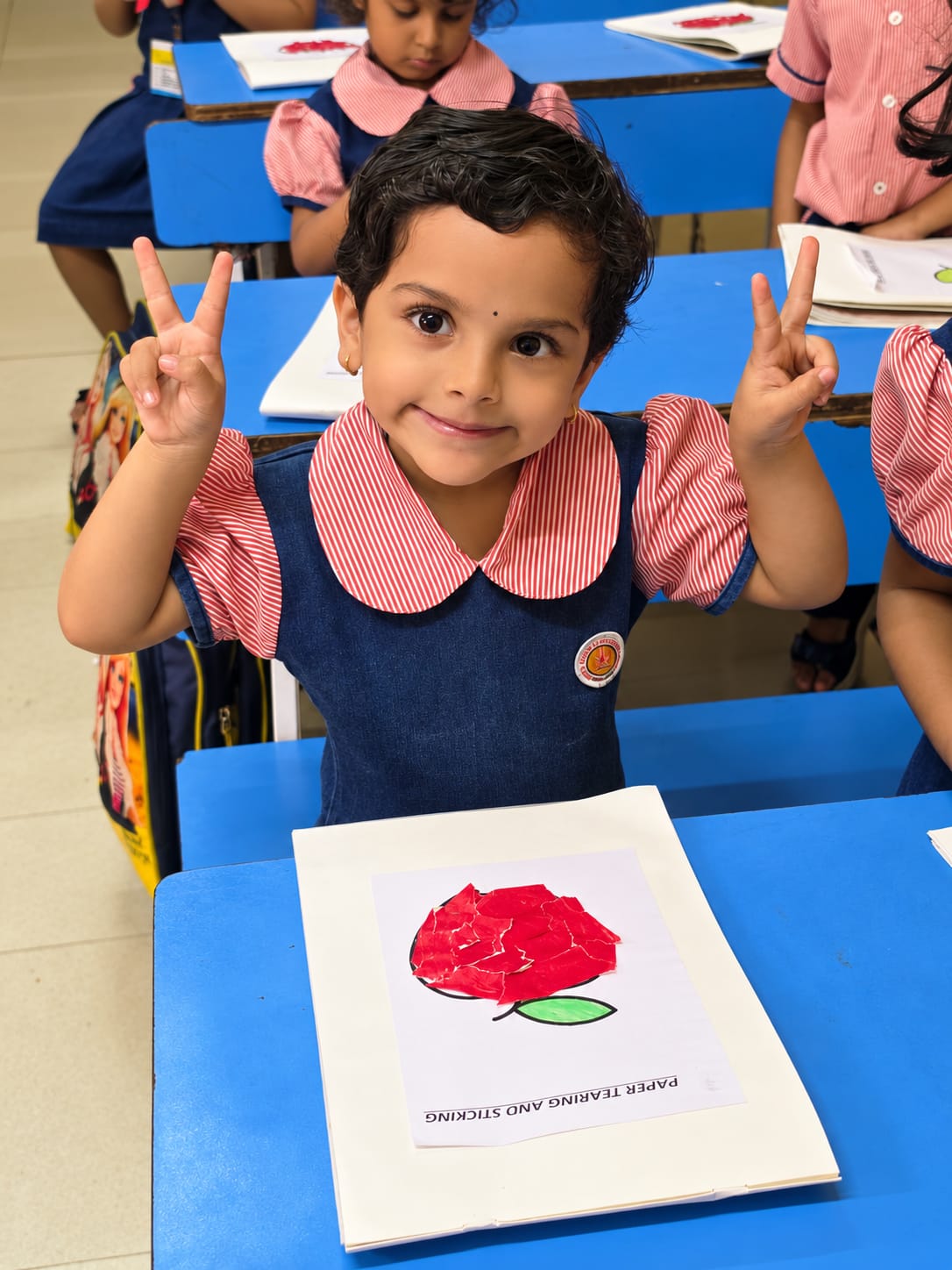 An Early Years student presenting her classroom artwork
