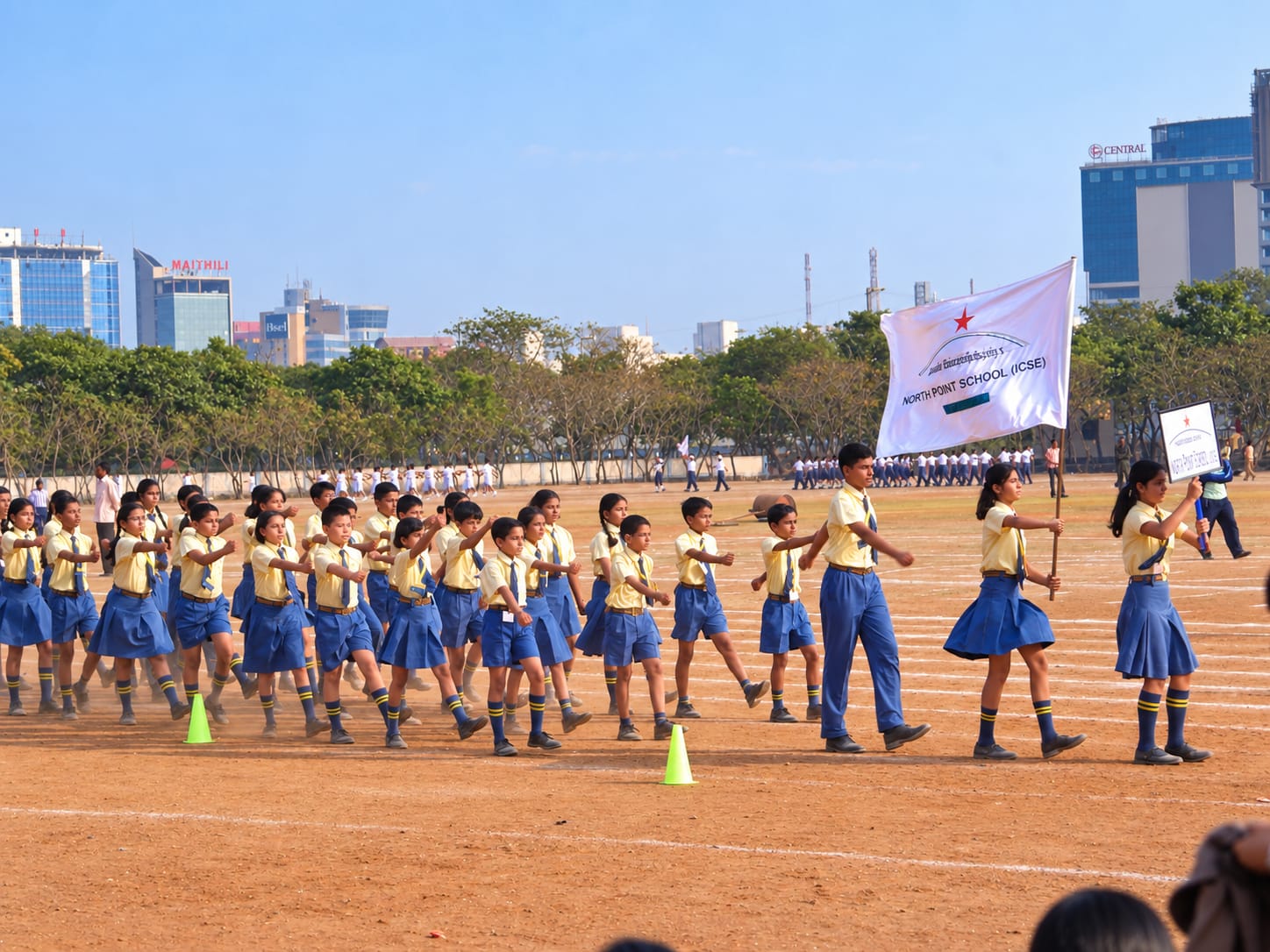 North Point School students marching with the school flag on the sports ground